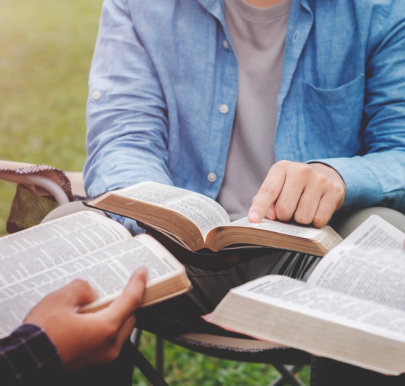 Students with open Bibles studying together outdoors