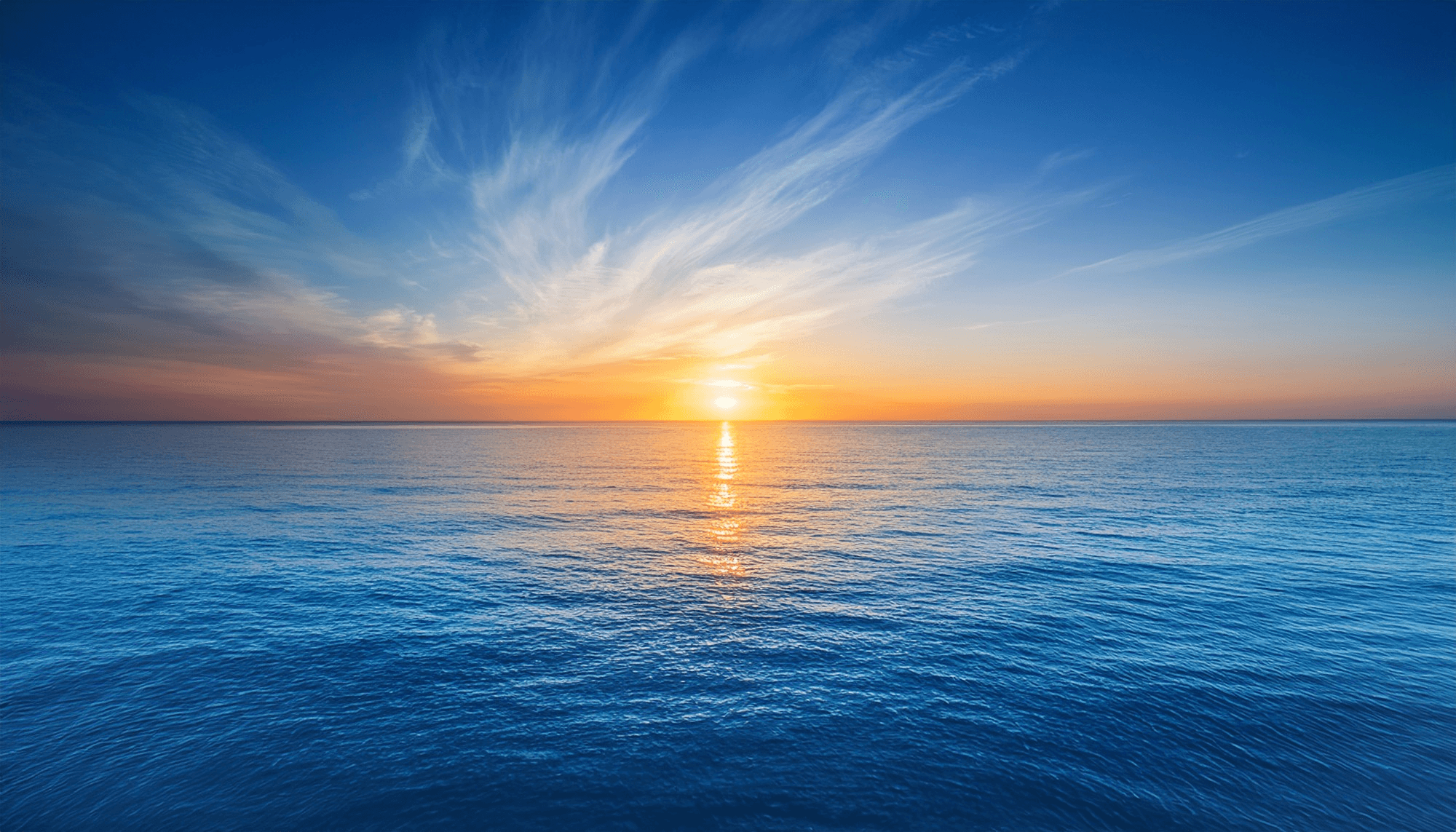 The sun setting over a calm ocean