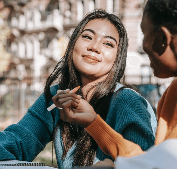 A student smiling outside on campus