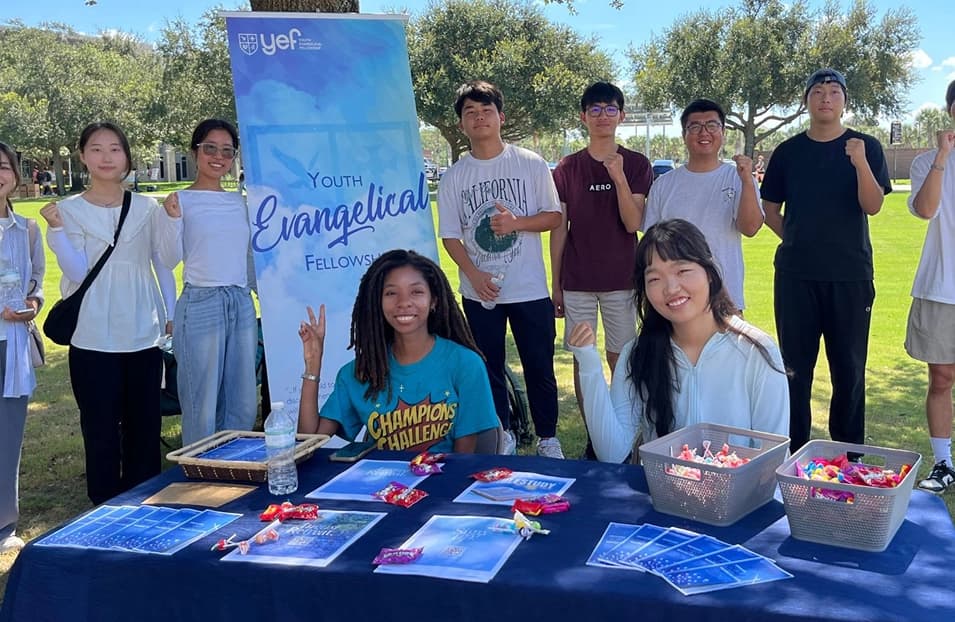YEF students sharing the Gospel at a campus outreach table