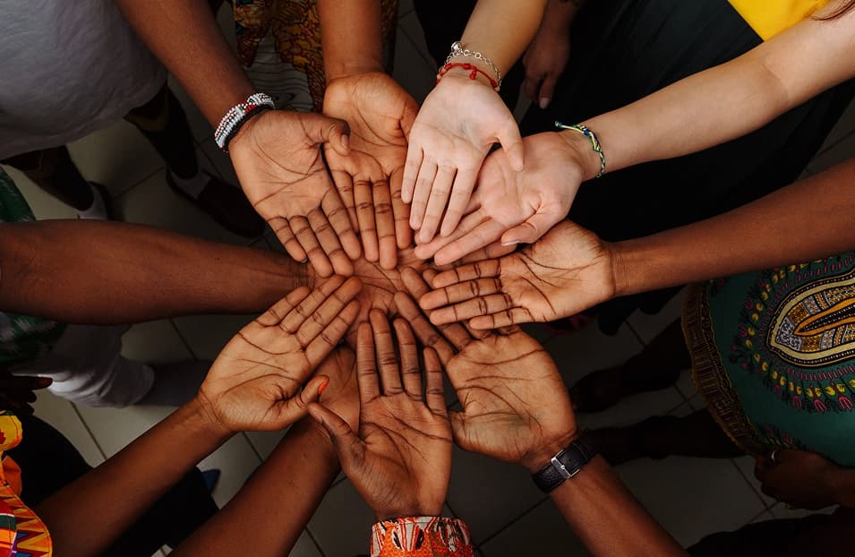 A team stacking hands together in unity