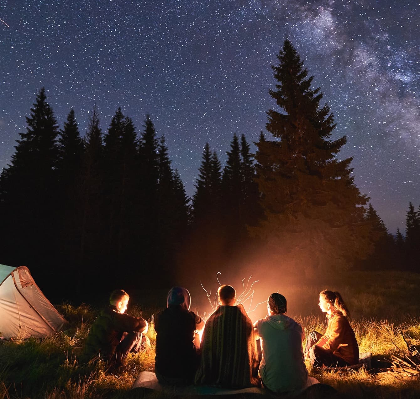 Students gathered around a campfire under a starry sky at Summer Training