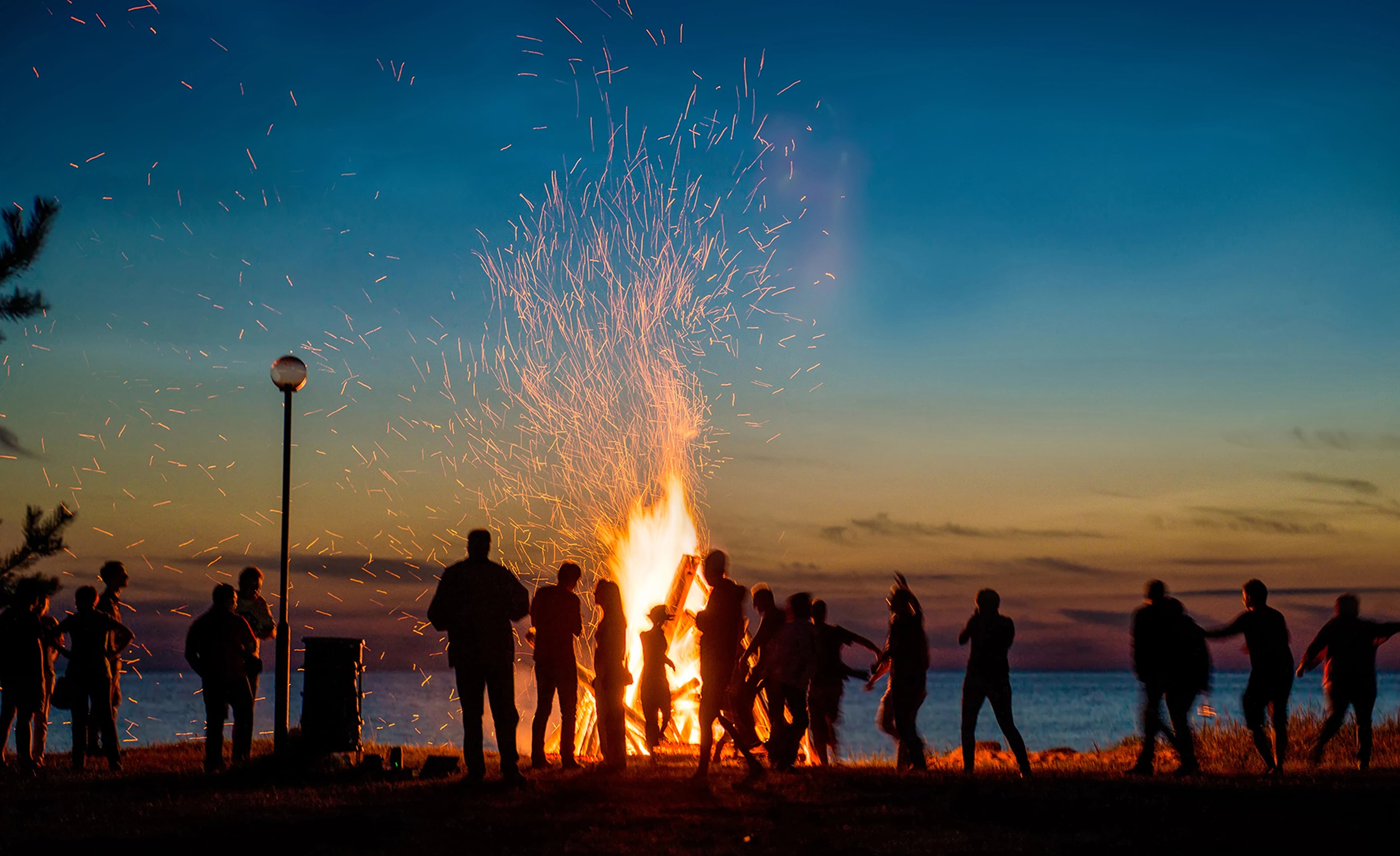 Youth gathered around a bonfire at dusk