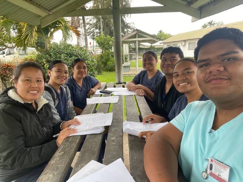YEF Tonga nursing students studying Romans around a picnic table