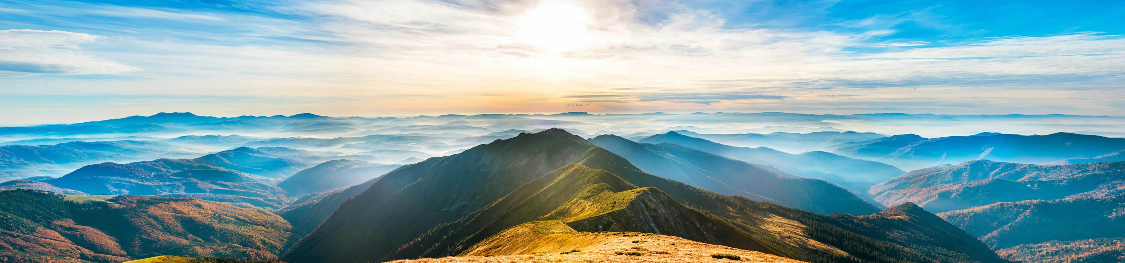Sunlit mountain ridges receding into morning haze