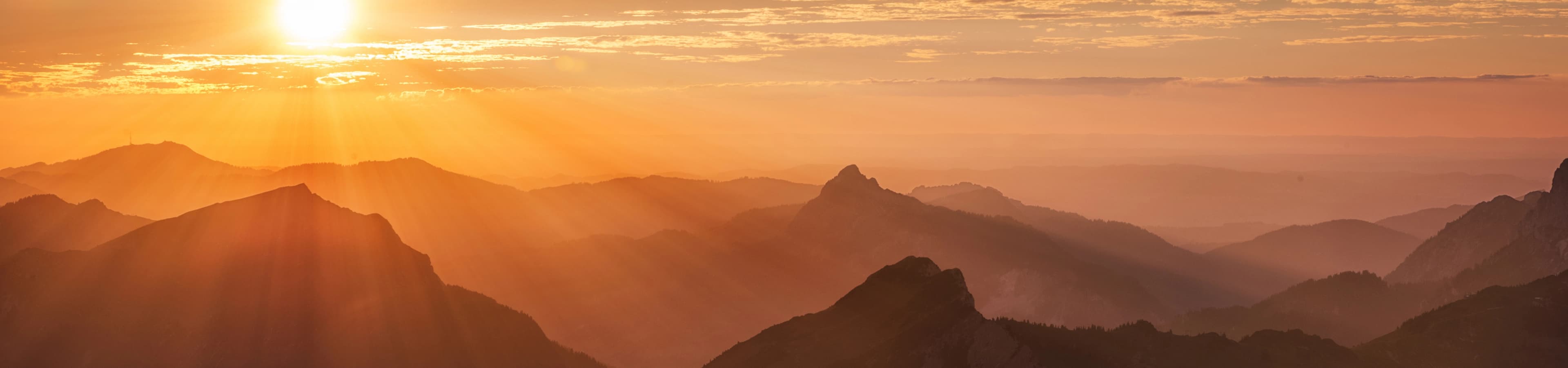 Sunrise over layered mountain ridges